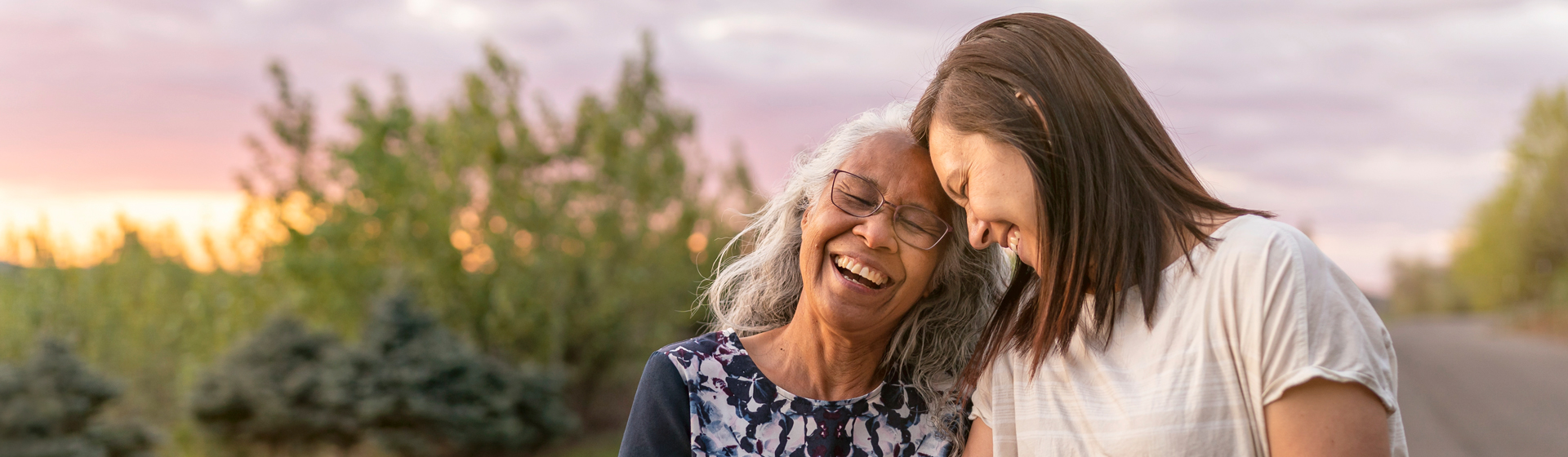 Mother and daughter laughing outside
